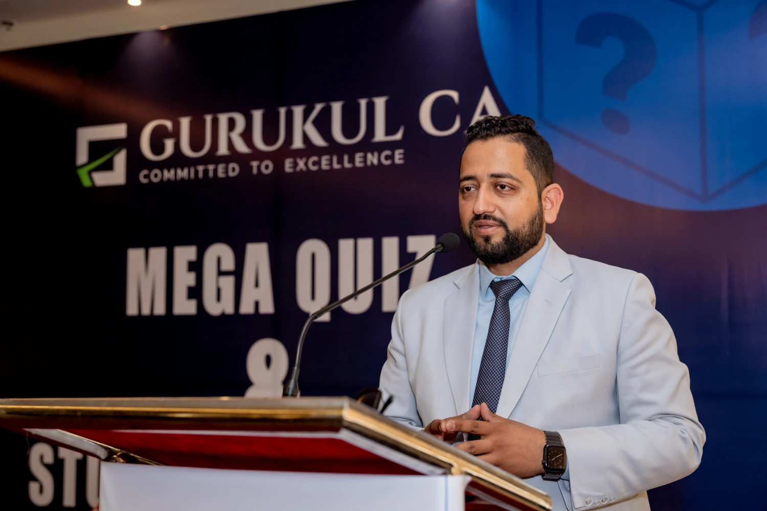 speaking on stage at Gurukul CA Mega Quiz