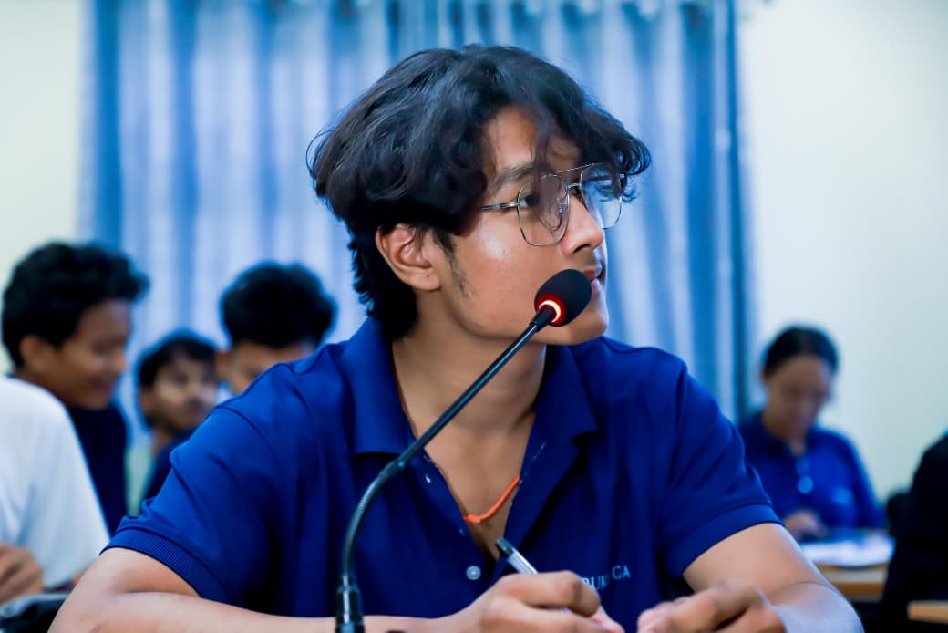 Student speaking into a microphone during an academic session
