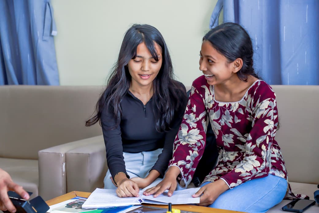 Two students studying together and discussing their notes